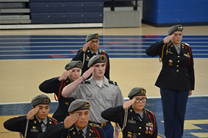 students standing at attention and saluting