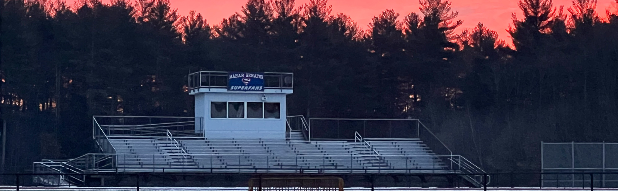 View of football field bleachers at sunset