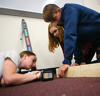 Three students building a wood project